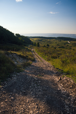 Mountain road stretching into the distance clouds on a summer day.の写真素材