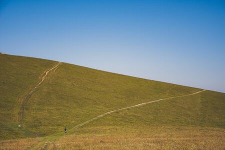 Mountain road stretching into the distance clouds on a summer day.の写真素材