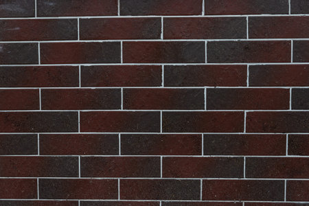 The texture of the masonry of dark red brick