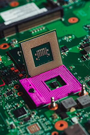 Laptop processor in the hands on the background of the motherboard macro photoの写真素材