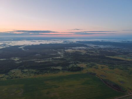 View from the height of the quadcopter on the landscape before dawn , fog dissipates in the fields near the forest.の写真素材