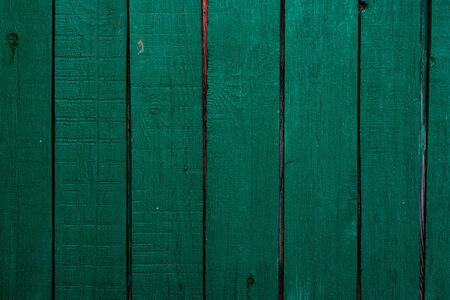 The texture of the green wall of wooden boards with cracked paint.の写真素材