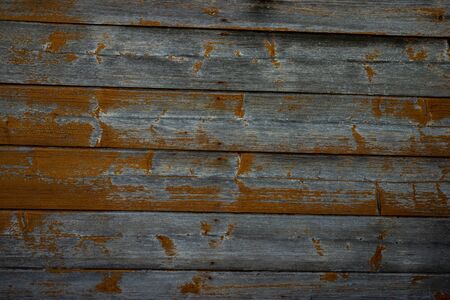 Texture of an old wooden wall of boards with peeling orange paintの写真素材