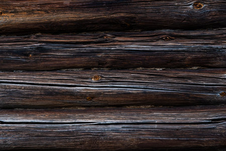 Texture of an old wooden wall of logs with peeling green paint