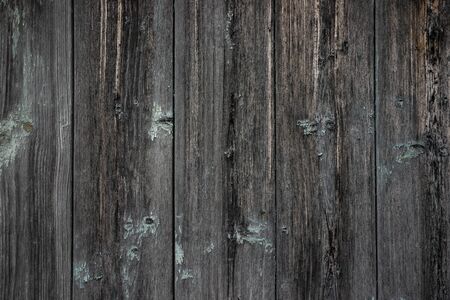 The texture of an old unpainted wall of wooden boards . Lots of knots in the boardsの写真素材