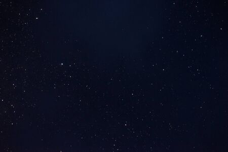 Stars in the night sky through the cloudsの写真素材