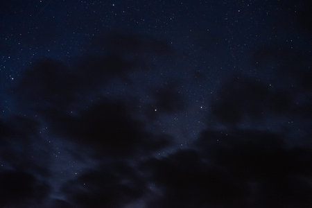 Stars in the night sky through the clouds