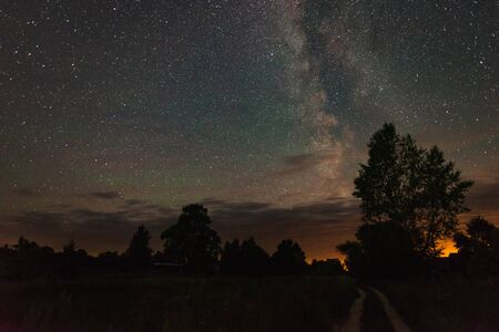 Road in the countryside summer starry night among the trees.の写真素材