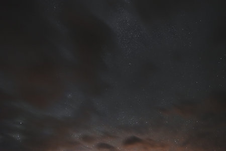 Stars in the night sky through the clouds on a summer night