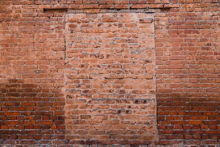 The road to the past and the future is buried, you need to live in the present. The door is laid with red bricks in a large brick wall.の写真素材