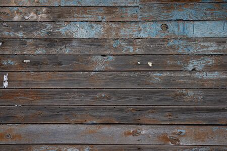 The texture of an old wall of boards with peeling blue paintの写真素材