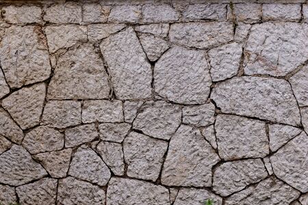 Texture of stone wall made of grey stonesの写真素材