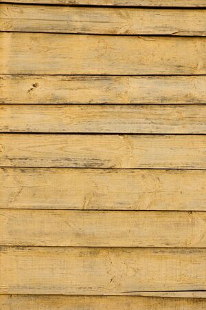 Texture of a yellow fence made of wooden boardsの写真素材