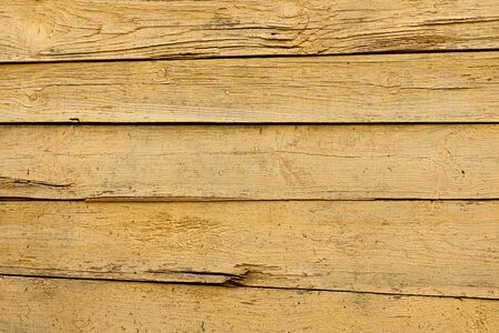 Texture of a yellow fence made of wooden boardsの写真素材