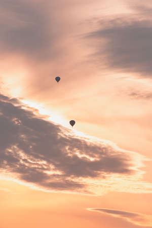 Two balloons on a background of pink sunset and cloudsの写真素材