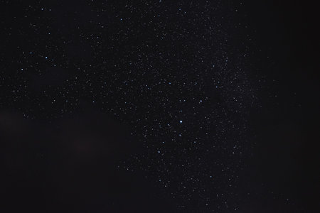 Stars in the night sky through the clouds on a summer night