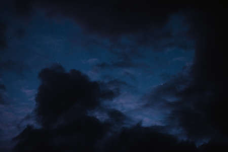 Stars in the night sky bring the clouds togetherの写真素材