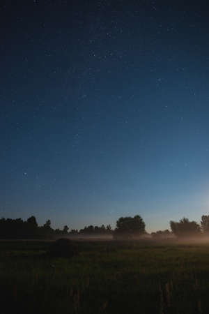 Moonrise over the field on a summer starry nightの写真素材