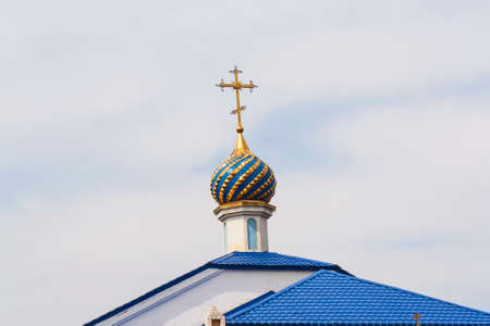 Golden cross on the church against the blue skyの写真素材