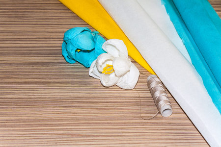 Homemade flowers of colored corrugated paper corrugated paper lie on the surface of the tableの写真素材