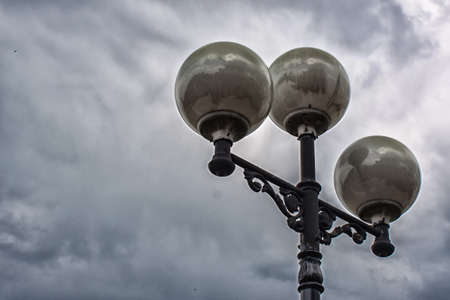 The lights on the pole in the background of a stormy skyの写真素材