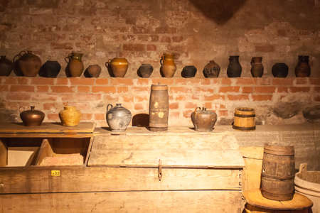 Old crockery standing on shelves in a brick basementの写真素材