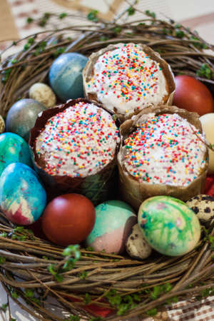 Easter treat kulich and eggs in a symbolic nest on the tableの写真素材