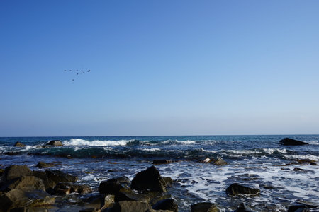 Splashing waves in a storm at sea with blue sky