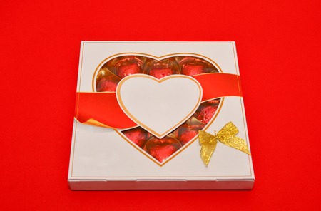 Beautiful love concept for Valentines day. Romantic box of sweets on the red background.の写真素材