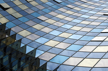 Perspective view of the modern building facade with clouds reflections on the windows glassの写真素材