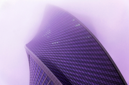 Violet toned futuristic photography of the modern skyscraper standing in the scotch mistの写真素材