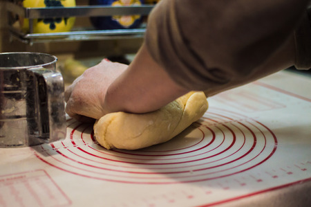 Close-up view of the female hands kneading dough for the homemade cake.の写真素材