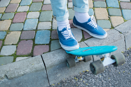 Young man ready for skateboarding in the park standing on the pavement. Side view. The concept of modern culture, penny skateboarding, outdoor activity, modern lifestyle.の写真素材