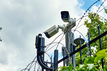 CCTV camera and motion detectors on the fance with barded wire