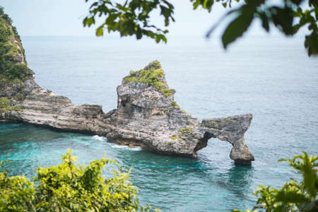 Beautiful Natural Rock Arch Island in the Sea at Atuh Beach in Nusa Penida, Bali, Indonesia. Aerial View.の写真素材