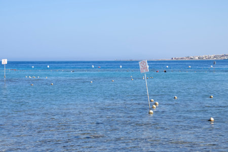 A clear blue sea with buoys and a distant shore, offering a tranquil and peaceful marine view.の写真素材