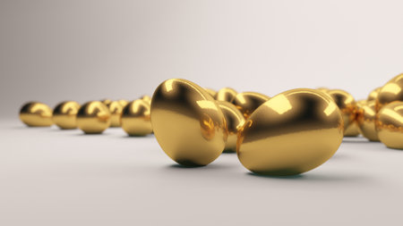 Close-up view of multiple golden eggs illuminated by soft lighting, creating a warm, inviting scene with reflections on their smooth metallic surfaces.の写真素材