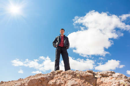 Bottom view of the man standing on a rockの写真素材