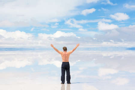 Rear view of a man worshiping in natureの写真素材