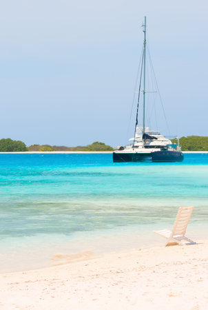 Beach chair and boat at the beach of archipelago Los Roques, Venezuela