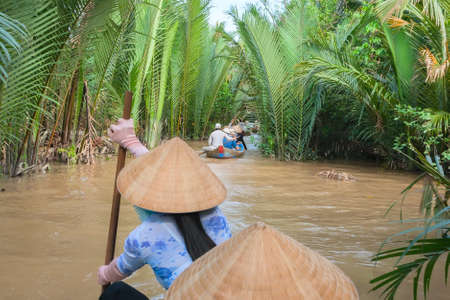 Vietnamese woman paddling in the Mekong River Vietnamのeditorial素材