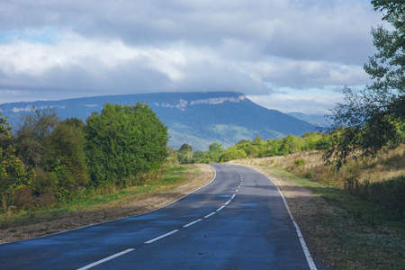 paved mountain road on a background of mountainsの写真素材
