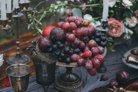 ripe red grape on a vintage bowl on a wooden table with a tableclothの写真素材