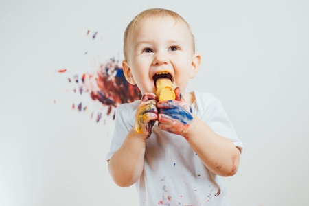 The child got dirty colors. Eat paint and smiles.