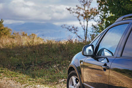black car on a mountain road on a background of mountainsの写真素材