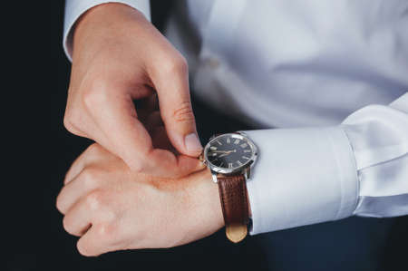 The man in the white shirt in the window wears watchesの写真素材