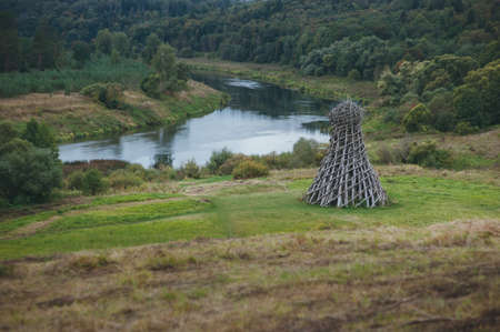 art object wooden tower with arrows on a background of the riverの写真素材