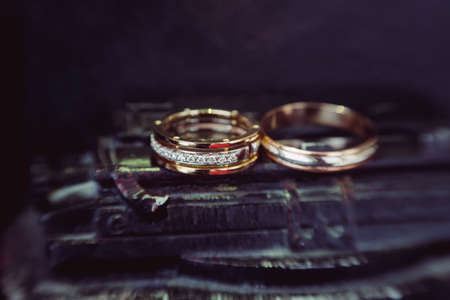 Beautiful wedding golden rings on dark backgroundの写真素材