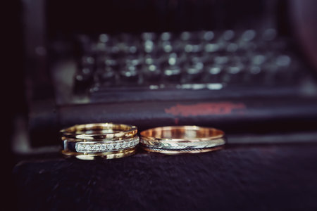 Beautiful wedding golden rings on dark backgroundの写真素材