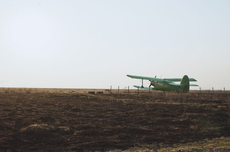 old green airplane on the field on a sunset background